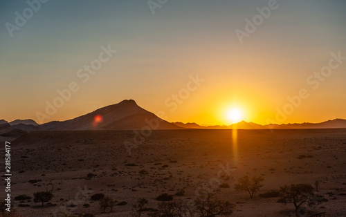 The rsing sun above the desert of Namibia, near the Khomas region.