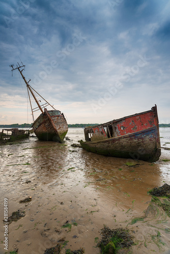 Fotografiet Abandoned fishing boats under a brooding sky