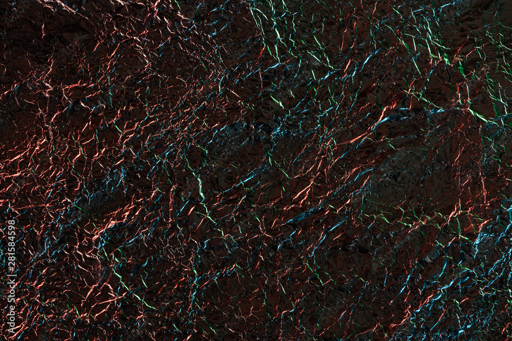 top view of silver crumpled foil with colorful lighting in dark top view of silver crumpled foil with colorful lighting in dark