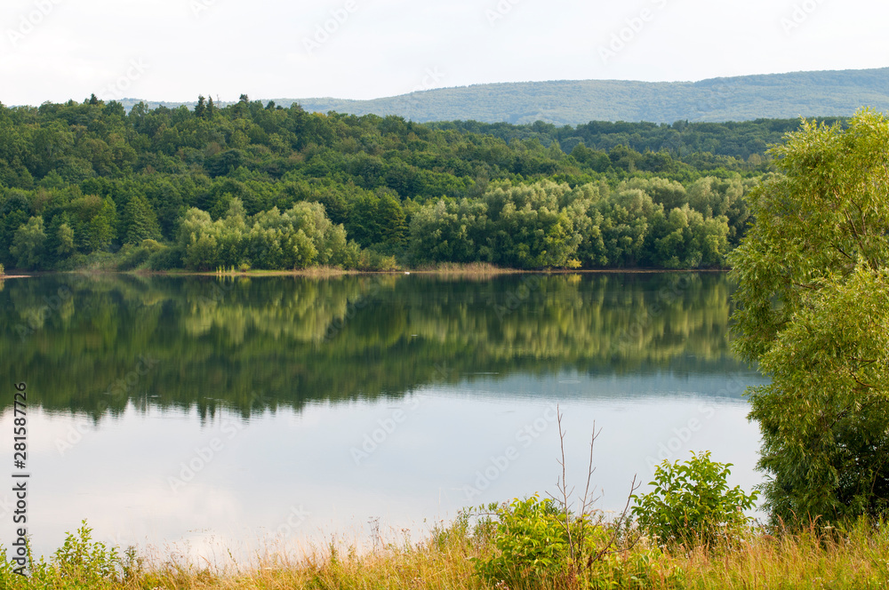 beautiful summer lake against the background of high mountains and blue sky