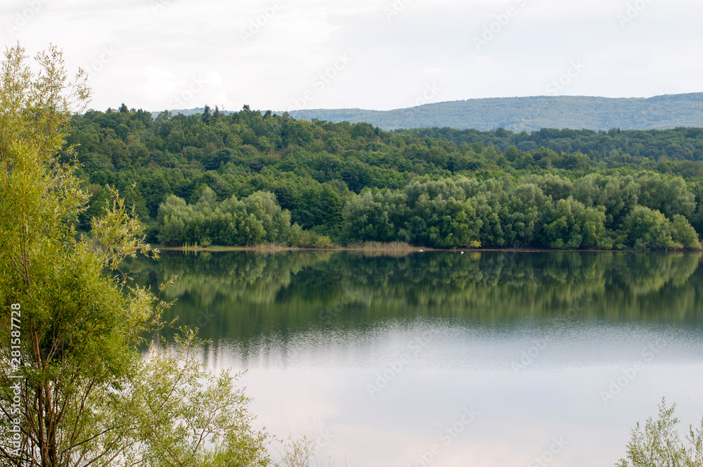 beautiful summer lake against the background of high mountains and blue sky