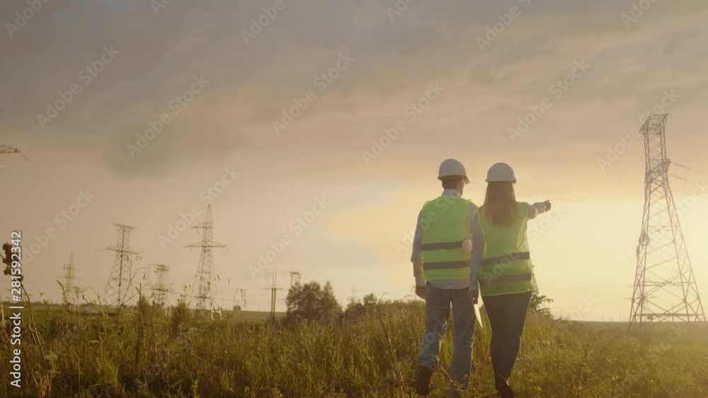 Back two the Engineer and the controller with a tablet PC and the drawings are about lines and transmission towers and discuss the expansion plan and transportation energy for towns and cities Back two the Engineer and the controller with a tablet PC and the drawings are about lines and transmission towers and discuss the expansion plan and transportation energy for towns and cities