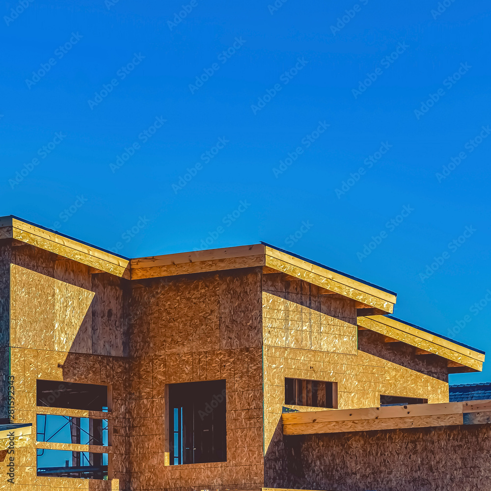 Exterior of a house under construction against clear blue sky on a sunny day Exterior of a house under construction against clear blue sky on a sunny day