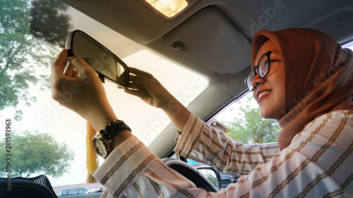 Wallpaper Mural close up shot of Muslim women wearing Asian hijab adjusting the mirror Torontodigital.ca