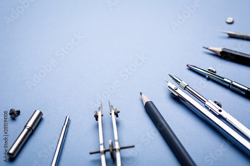 Tools for drawing blueprints laid out in a semicircle on a blue background photo