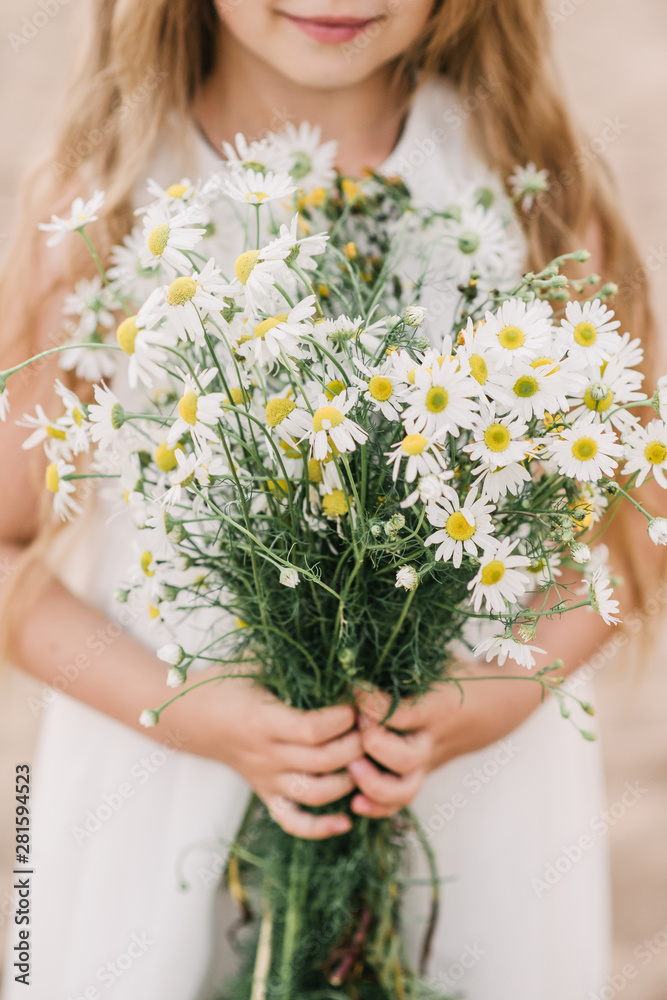 girl holding a bouquet of daisies