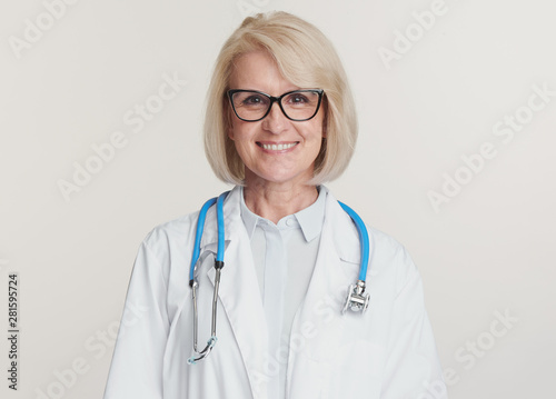 Friendly senior woman doctor is smiling. Isolated on white