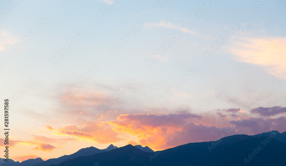 Fototapeta premium soft sunset sky. pink and gold clouds. High mountains. Natural background.