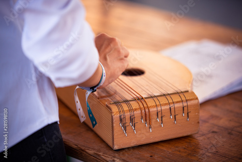 Fingers playing on traditional music instrument zither