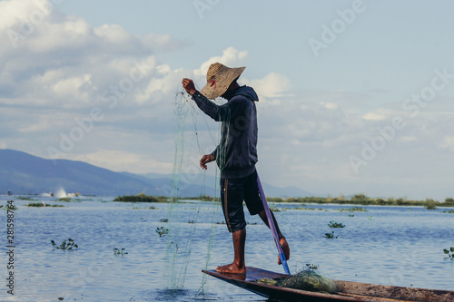 fisherman with net at lake on canoe