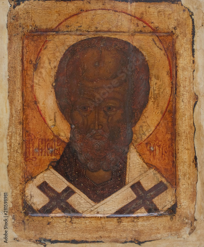 Fotografie Fragment of the ancient Christian icon of St. Nicholas on a tree.