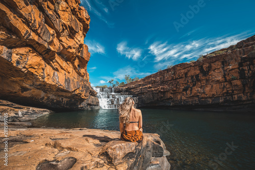 woman sitting in front of waterfall