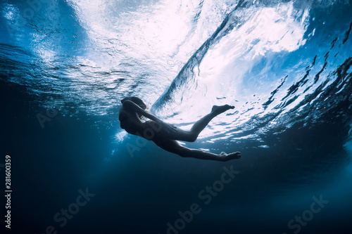 Fotografía Young woman dive underwater with under barrel wave
