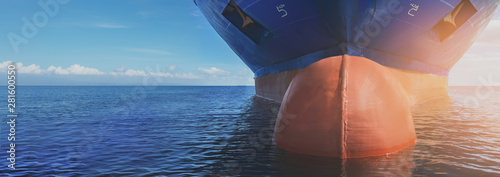 Close up of large blue merchant crago ship in the middle of the ocean underway. Performing cargo export and import operations.