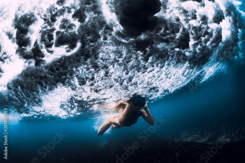 Young woman swim underwater with ocean wave. © artifirsov