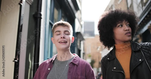 Young adult lesbian couple walking in city in summer photo