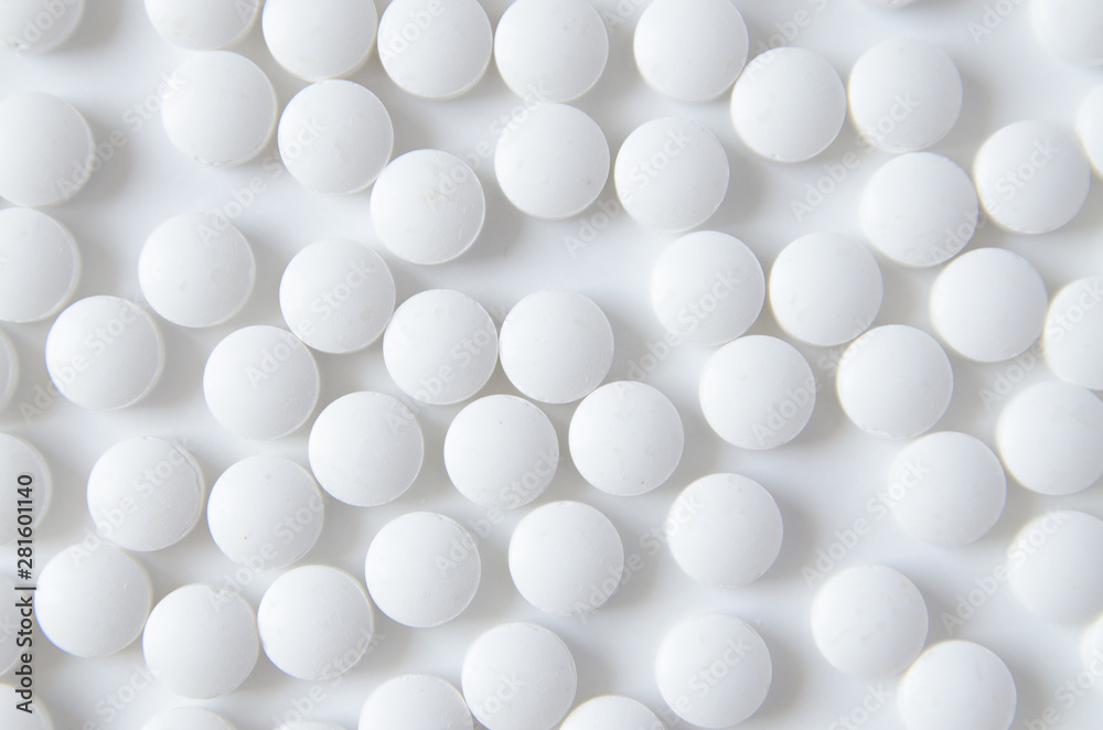 scattered white pills on the white table scattered white pills on the white table