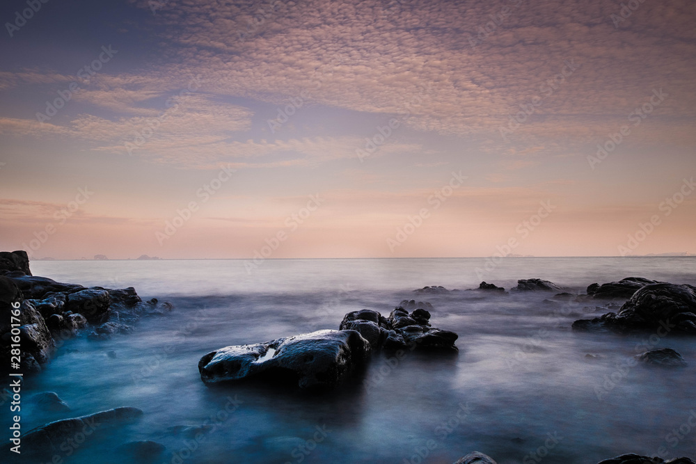 Obraz premium Long exposure image of Dramatic sky and wave with rock sea in sunset scenery background