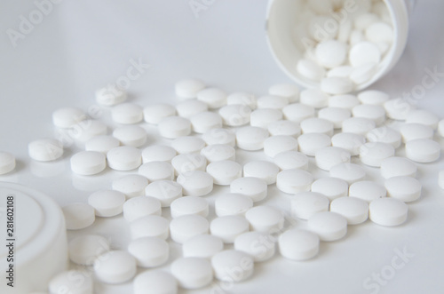scattered white pills on the white table