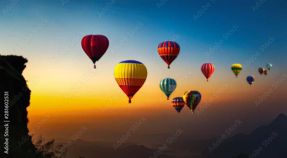 Fototapeta premium Hot air balloons flying over the sunrise mountain at phucheefa mountain. Chiang Rai Province, Thailand