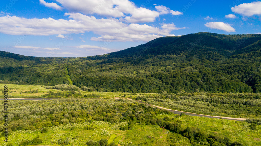 Fototapeta premium aerial shoot of green landscape in the mountains