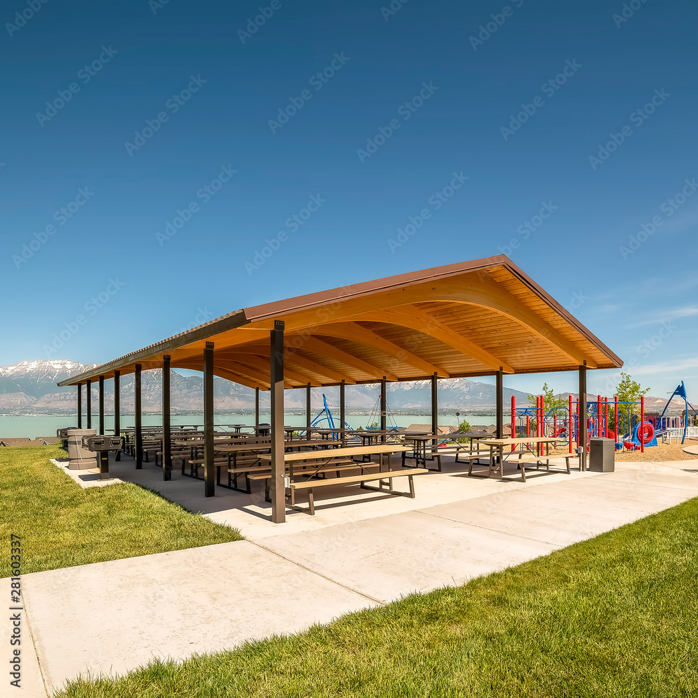 Picnic pavilion and playground with view of lake snow peaked mountain and sky