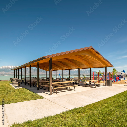 Picnic pavilion and playground with view of lake snow peaked mountain and sky © Jason
