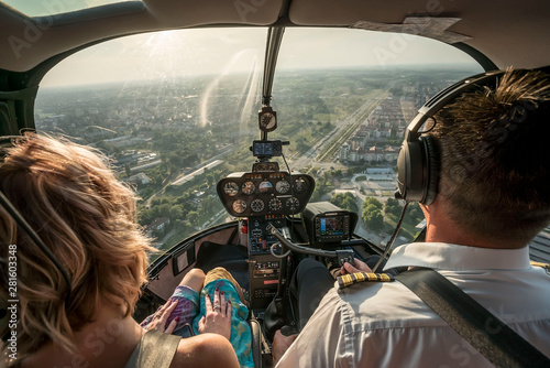 Obraz na płótnie Portrait of beautiful blonde women and pilot enjoying helicopter flight