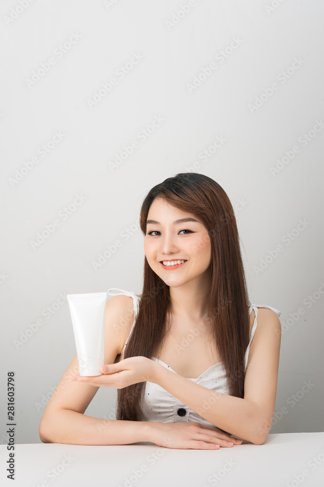 Asian woman model present showing cosmetic products isolated on white background Asian woman model present showing cosmetic products isolated on white background
