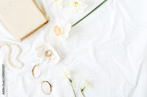 Minimal fashion French style composition with women's accessories: earrings, necklace, rings on white linen. Flat lay, top view.