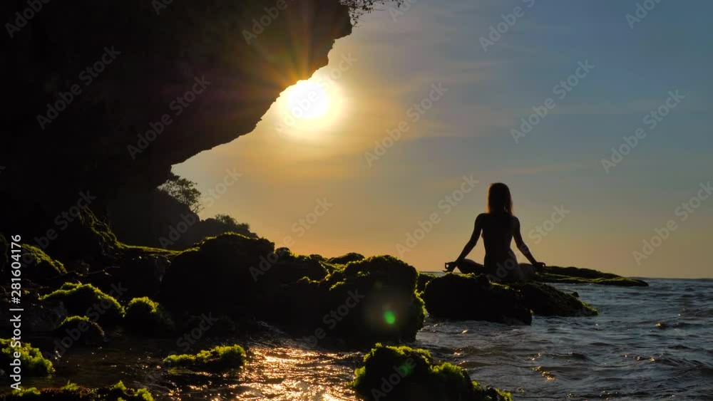 Serenity and yoga practicing at sunset, female meditation, handled shot, no color grade