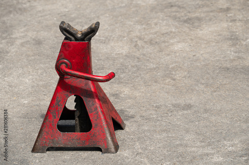 Used red high lift jack stand on the floor.