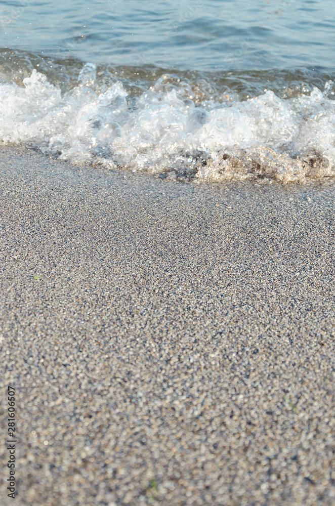 Closeup of sandy beach with soft incoming waves. Selective focus Closeup of sandy beach with soft incoming waves. Selective focus