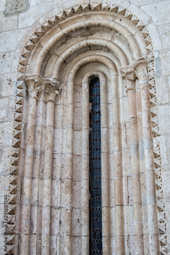fragment of narrow Romanesque window on a church facade fragment of narrow Romanesque window on a church facade