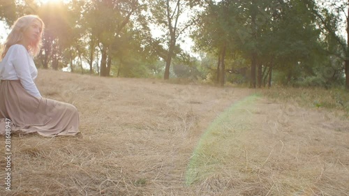 Wallpaper Mural beautiful girl sits in a meadow flooded with sunlight in a dress, romantic mood, young woman enjoys nature, concept female beauty Torontodigital.ca
