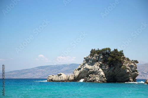 A dragon-like cliff on a beach with bright blue water in Albania © lanamilana