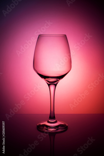 Wine glass on a purple red orange background.