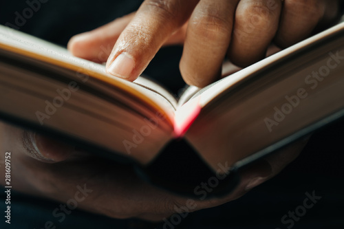 close-up of finger pointing text in Bible.close up of man reading through the Bible.
