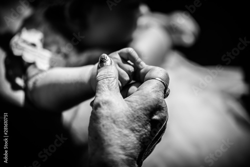 Senior hand holding baby hand