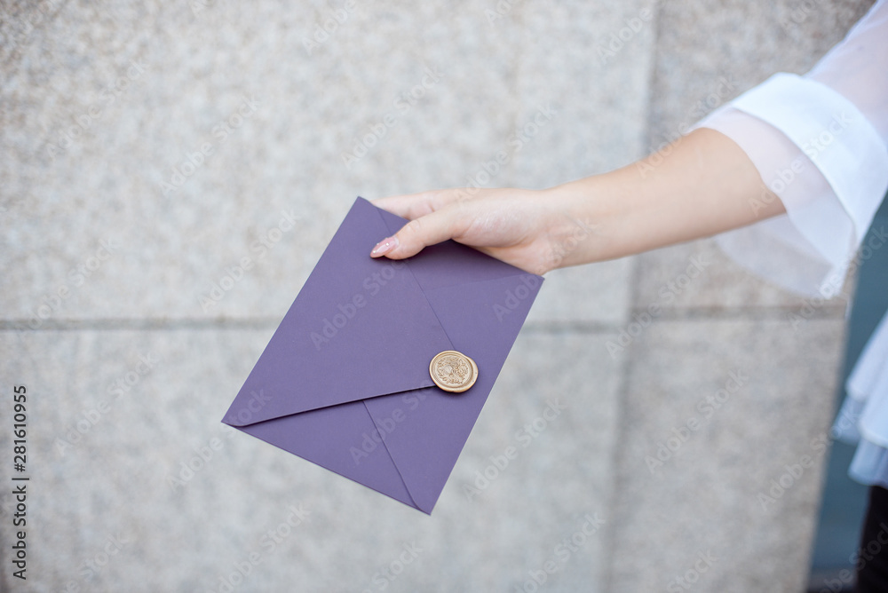 Young girl holds mail invitation cards in her hand. Envelopes with wax seal in hands close-up Young girl holds mail invitation cards in her hand. Envelopes with wax seal in hands close-up