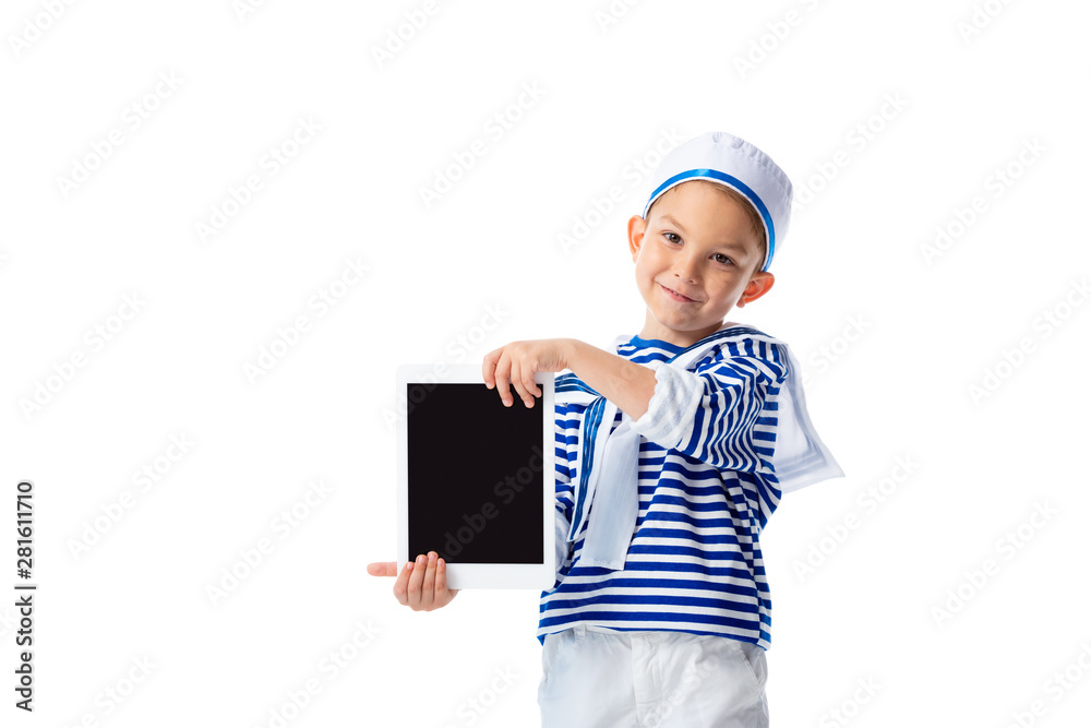 front view of smiling preschooler child in sailor costume holding digital tablet with blank screen isolated on white