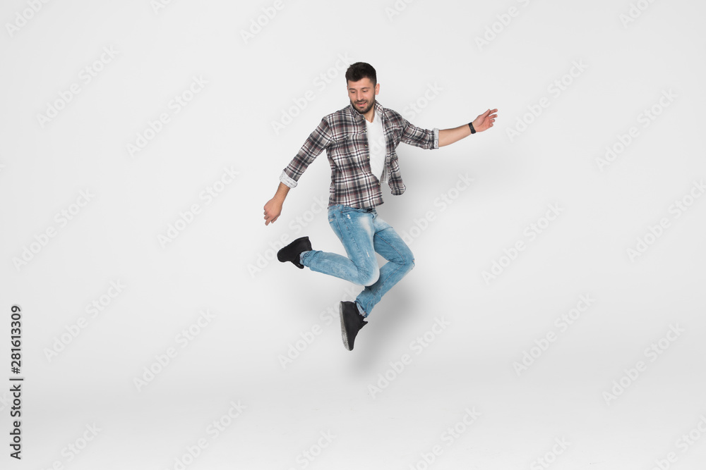 Happiness, freedom, movement and people concept. Smiling young man jumping in air isolated on white background Happiness, freedom, movement and people concept. Smiling young man jumping in air isolated on white background