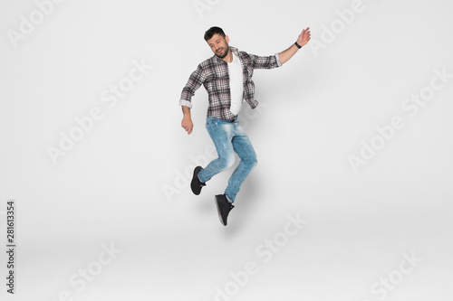 Happiness, freedom, movement and people concept. Smiling young man jumping in air isolated on white background