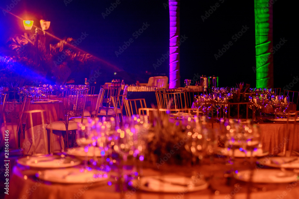 Obraz premium Served tables at the banquet in purple tones. Night photo.