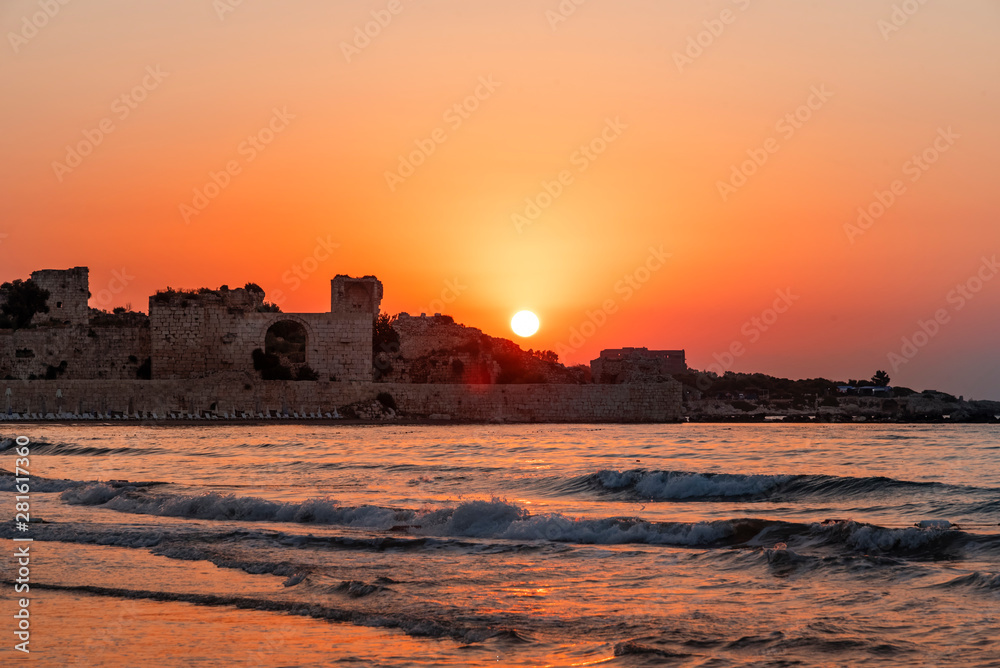 Beautiful golden sunrise over the sea and old fortress. 