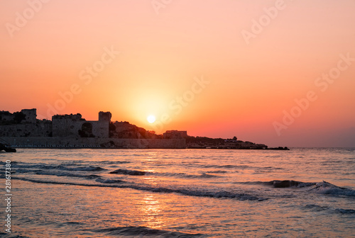 Beautiful golden sunrise over the sea and old fortress. 