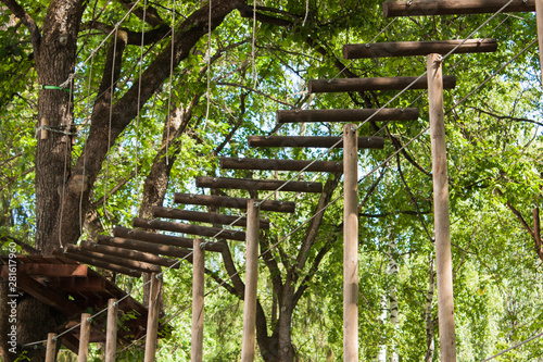 rope route with suspended wooden steps among the trees