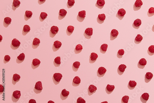Raspberries on pink background, berry flat lay