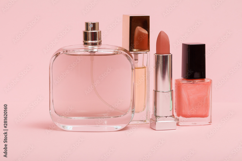 Women perfumes and cosmetics on a pink background. Women perfumes and cosmetics on a pink background.