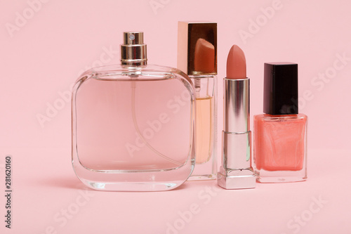 Women perfumes and cosmetics on a pink background.